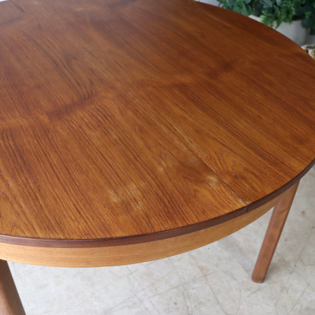 Vintage mid-century teak dining table with smooth rounded edge and visible wood grain, British-Denmark style.