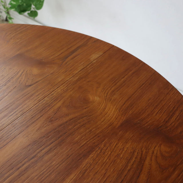Round vintage teak dining table top showing rich wood grain and smooth mid-century finish.