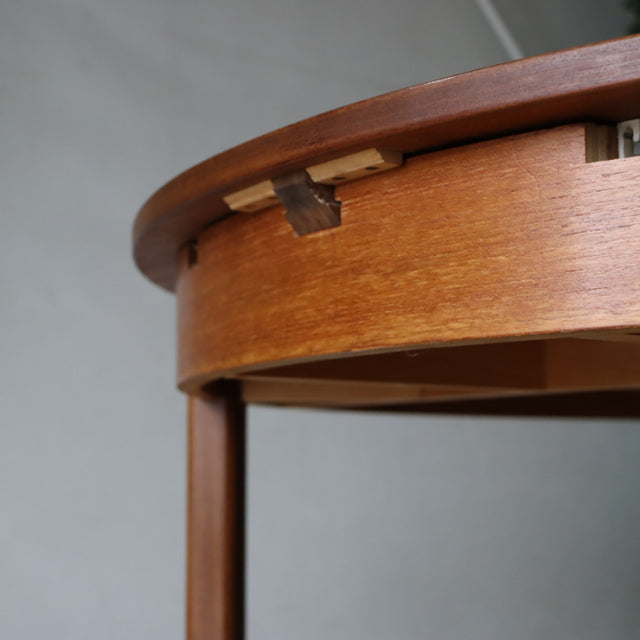 Mid-century vintage teak dining table with smooth wood grain, round edge, and slender British-style legs from Denmark.