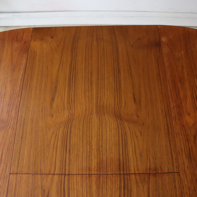 Mid-century vintage British teak dining table top showing rich wood grain and smooth finish.