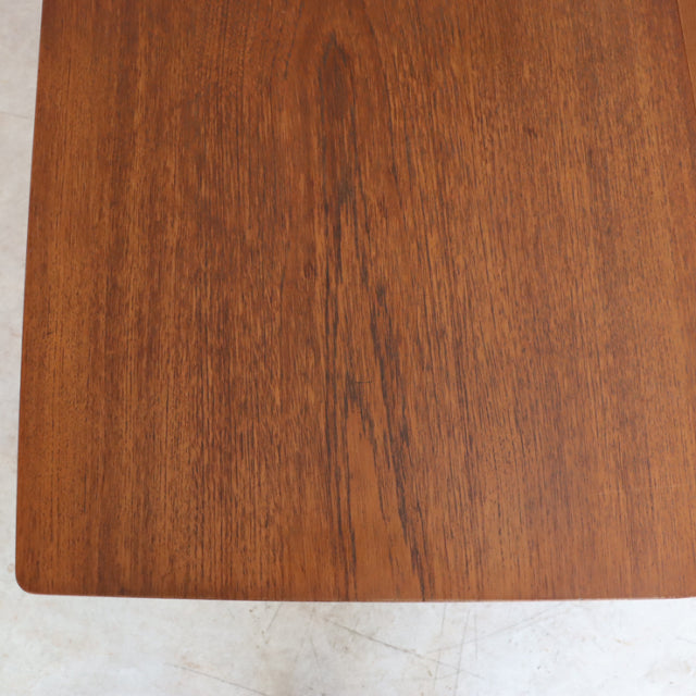 Vintage teak dining table top with warm brown wood grain, smooth mid-century British design from Denmark, soft rounded edges.