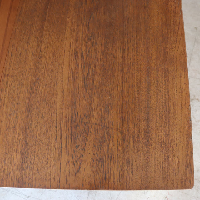 Mid-century vintage British teak dining table with rectangular top showcasing rich wood grain and smooth finish.