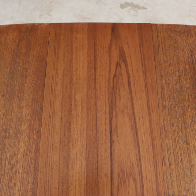 Vintage mid-century teak dining table showcasing rich wood grain with smooth finish and clean rectangular edges.