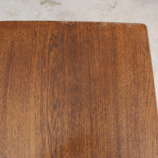 Vintage mid-century British teak dining table with smooth grain and rounded edges.