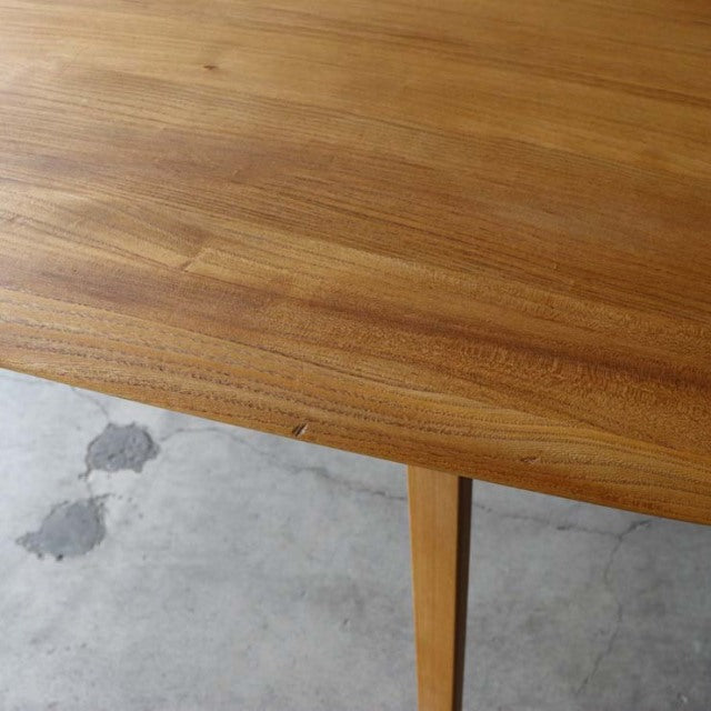 Mid-century British vintage ERCOL teak dining table with smooth wood grain and tapered legs on concrete floor.