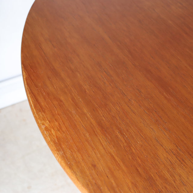 Oval teak dining table with smooth wood grain and mid-century British-Danish vintage design.