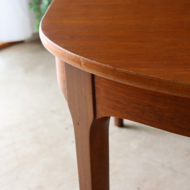 Mid-century vintage teak dining table by NATHAN with smooth oval top and angled British teak legs.