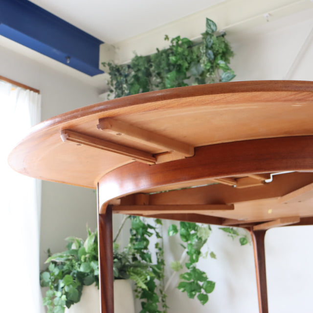 Vintage teak oval dining table by Nathan, showcasing British mid-century design with smooth wood grain and sturdy curved.
