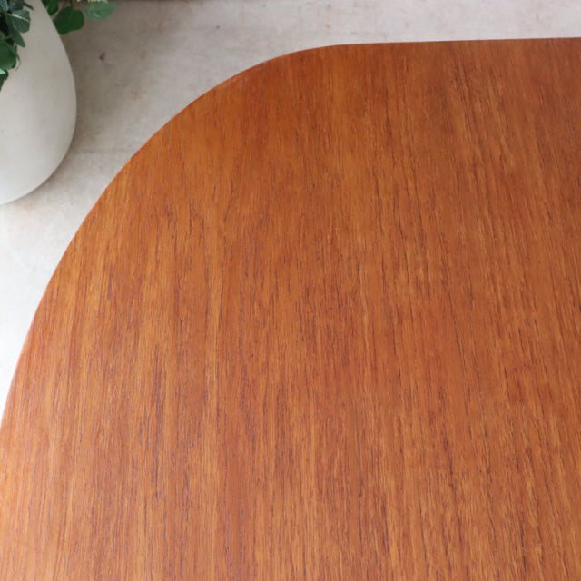 Oval vintage teak dining table top showing rich wood grain and smooth mid-century finish from British-Danish design.