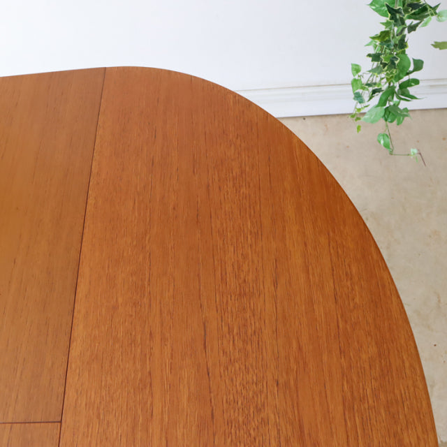 Vintage teak oval dining table top with smooth wood grain and subtle mid-century British design details.