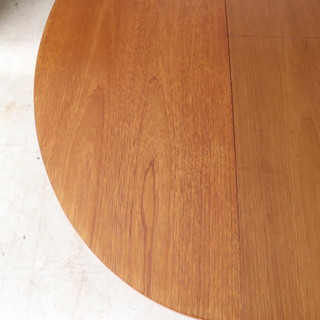 Round vintage teak dining table top with visible wood grain and mid-century British-Denmark design.