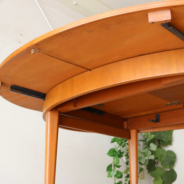 Mid-century teak dining table by Greaves and Thomas with rounded edges, smooth wood grain, and tapered legs, showcasing.