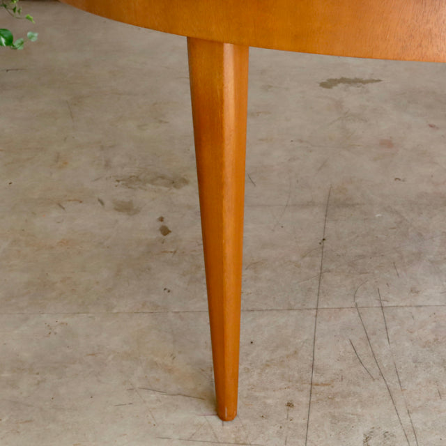 Mid-century British vintage teak dining table leg with smooth wood grain and tapered design on concrete floor.
