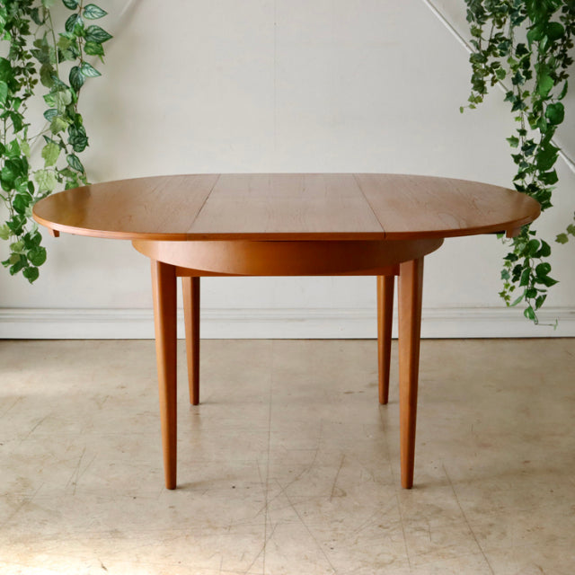 Vintage teak oval dining table by GREAVESandTHOMAS, mid-century British design with tapered legs and smooth wood grain finish.