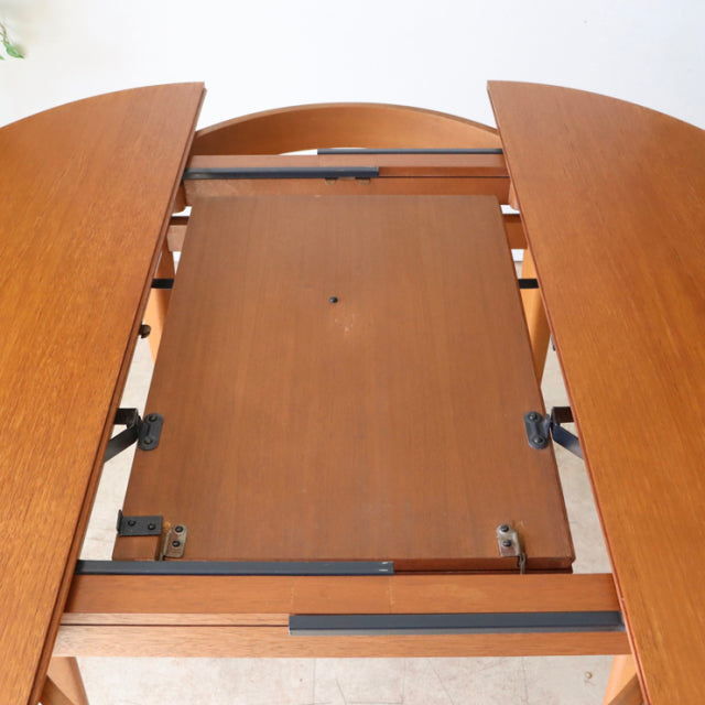Mid-century teak dining table by GREAVESandTHOMAS, British vintage with rich wood grain and metal extension hardware visible.