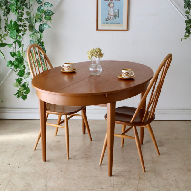 Vintage mid-century teak dining table by Greaves and Thomas from Denmark with oval top and tapered legs, paired with two.