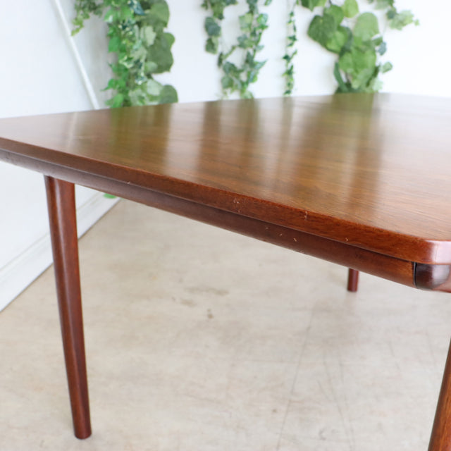 Vintage mid-century British McIntosh dining table in rich teak with smooth wood grain and tapered round legs.