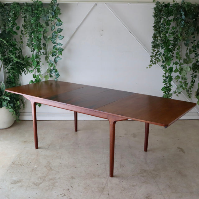 Mid-century vintage teak dining table by McIntosh with clean lines, slender tapered legs, and rich wood grain, showcasing.