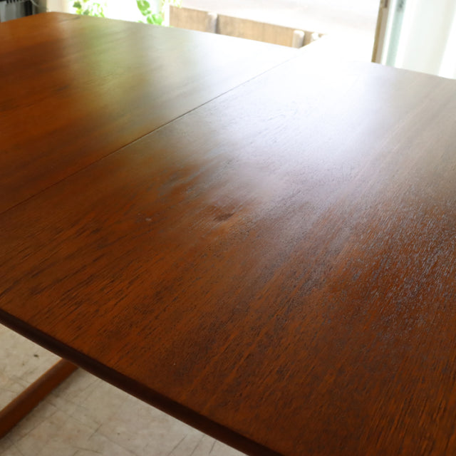 Vintage teak dining table with mid-century British design, smooth grain finish, rectangular top, and sturdy angled legs from .