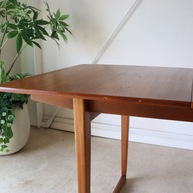 Mid-century vintage teak dining table with sleek British design, tapered legs, and rich wood grain.