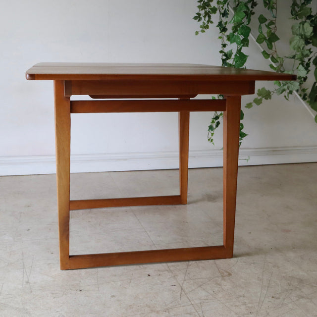 Mid-century vintage British teak dining table with clean rectangular top and sturdy squared legs, showcasing warm wood grain .