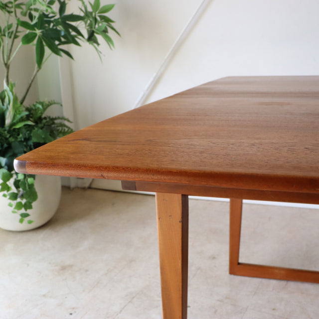 Mid-century British Denmark vintage teak dining table with rectangular top and tapered legs showing rich wood grain and.