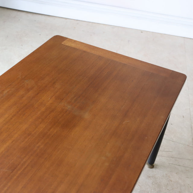 Vintage G-Plan teak coffee table with mid-century British design, rectangular top, and slender black tapered legs.