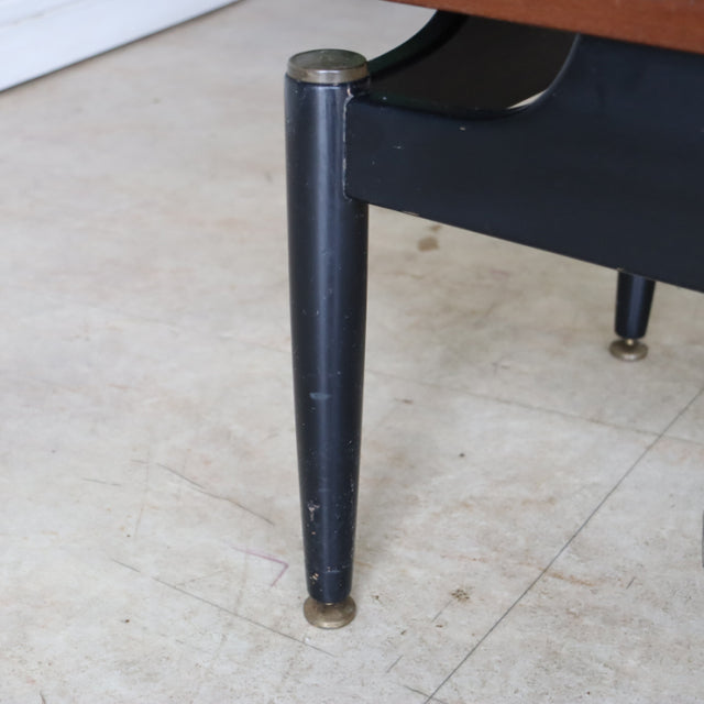 Mid-century British G-Plan teak coffee table with black tapered wooden leg and brass cap feet, vintage Danish design.