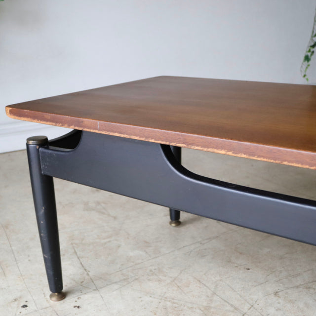 Vintage British mid-century G-Plan coffee table with teak top, black tapered legs, and sleek wood grain detailing.