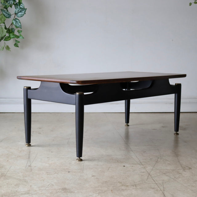 Vintage British G-plan mid-century teak coffee table with sleek black frame and tapered legs.