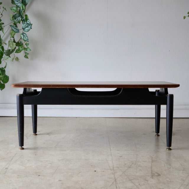 Vintage British mid-century G-Plan teak coffee table with black painted frame, sleek tapered legs, and visible wood grain.