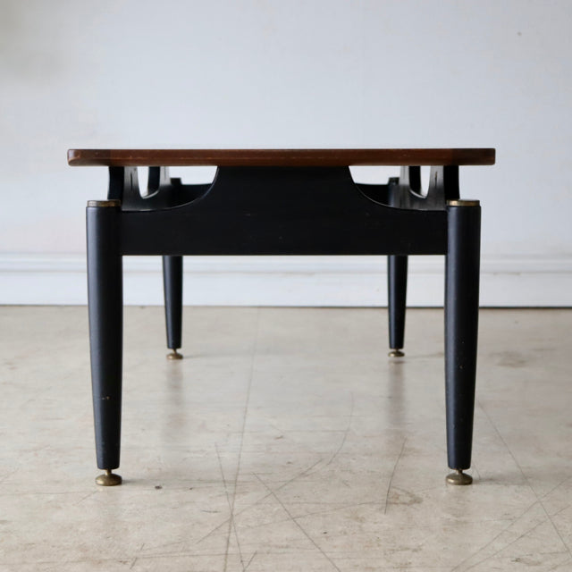 Mid-century British G-Plan vintage teak coffee table with black tapered legs and brass-capped feet, showcasing rich wood.