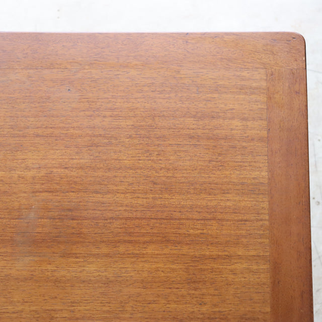 Corner close-up of vintage G-Plan teak coffee table showing smooth wood grain and rounded edge in mid-century British design .