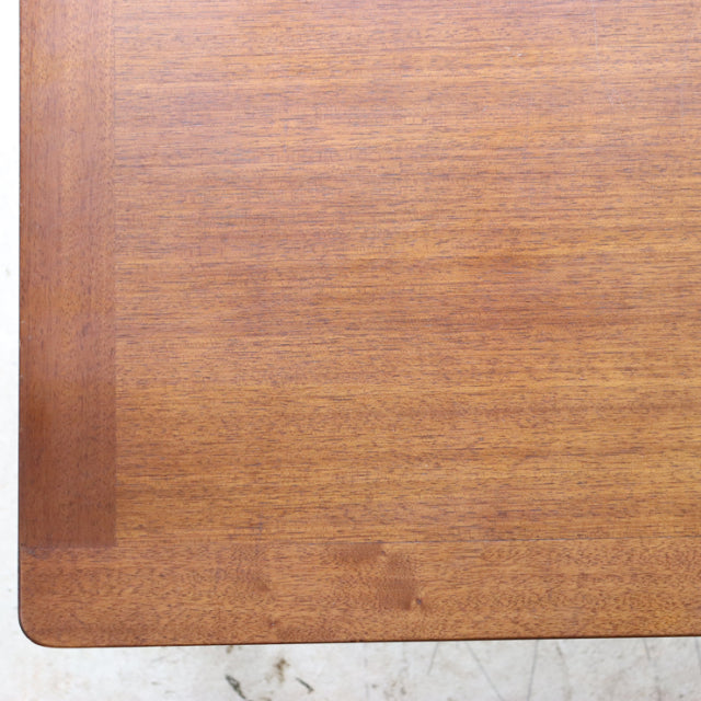 Vintage British mid-century G-plan teak coffee table corner with smooth wood grain and rounded edges.