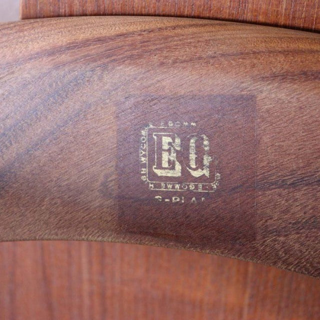 Close-up of vintage British G-PLAN teak coffee table corner showing rich wood grain and gold brand stamp on mid-century.
