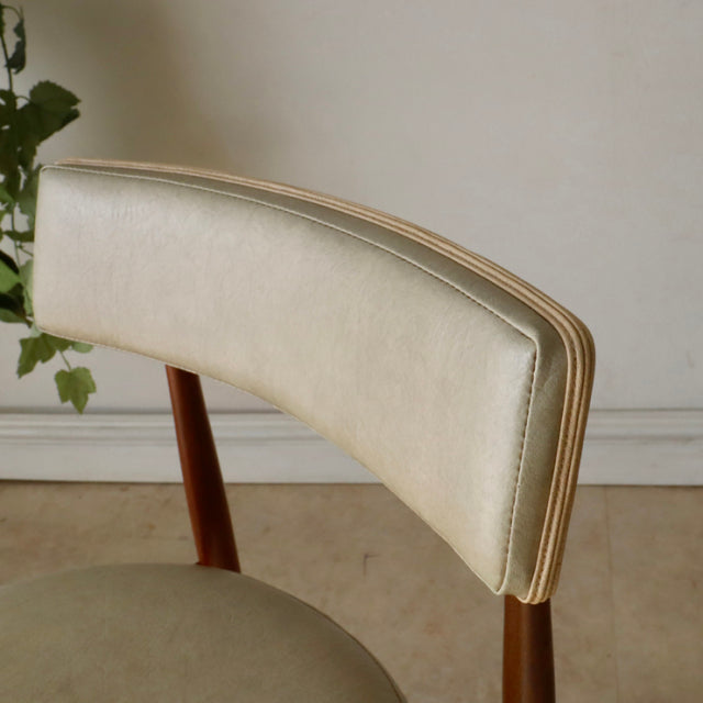 Vintage G-plan teak dining chair with curved cream leather backrest and tapered wooden legs, mid-century British design with .