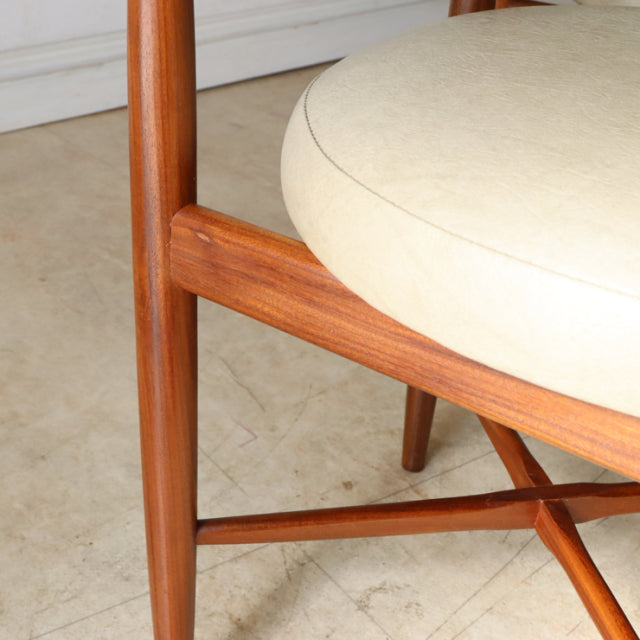 Mid-century British G-plan dining chair in teak wood with visible grain and beige rounded cushioned seat.