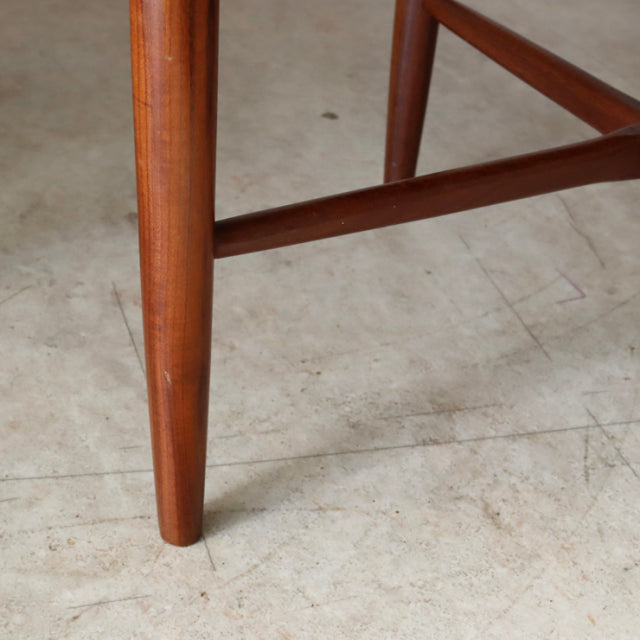 Close-up of vintage British mid-century teak dining chair leg with smooth wood grain and tapered design from G-plan Fresco.