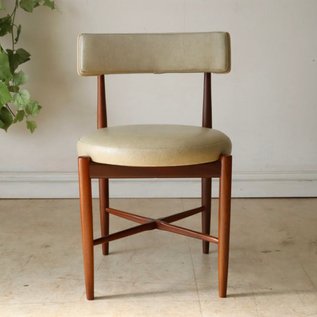 Vintage G-plan mid-century teak dining chair with cream upholstered seat and backrest, slender tapered legs, and.