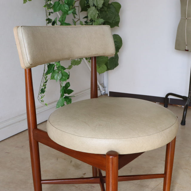 Mid-century British G-Plan vintage teak dining chair with round cream leather seat and curved backrest.