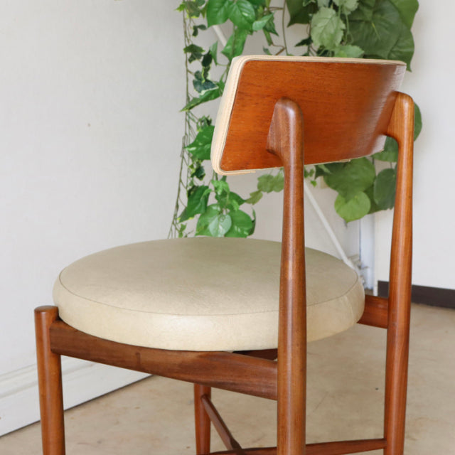 Vintage G-plan mid-century teak dining chair with round beige cushioned seat and curved wooden backrest.