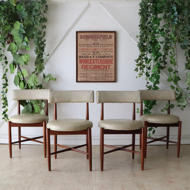 Set of four vintage mid-century G-Plan dining chairs in teak with beige upholstered seats and angled legs, British design.