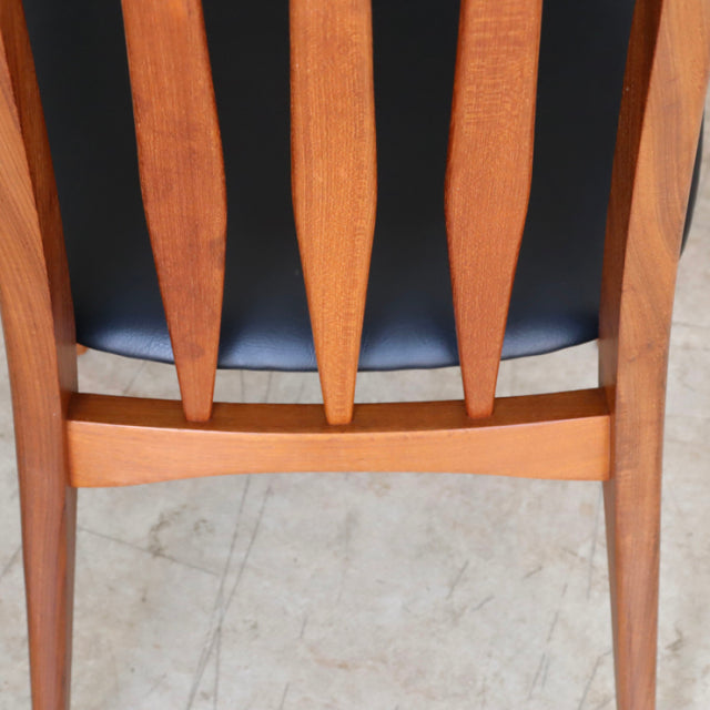 Mid-century vintage Danish teak dining chair back with tapered vertical slats and visible wood grain.