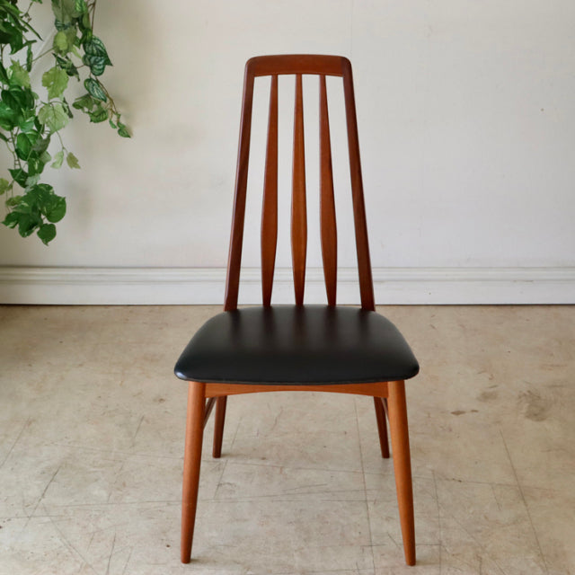 Mid-century Danish vintage dining chair with teak wood frame, vertical slat backrest, and black upholstered seat.
