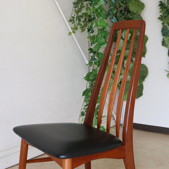 Mid-century Danish vintage teak dining chair with tall slatted back and black leather seat cushion, slender tapered legs.