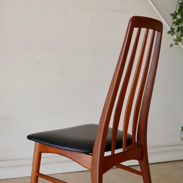Vintage mid-century Danish dining chair in warm teak with sleek vertical slat backrest and black upholstered seat.