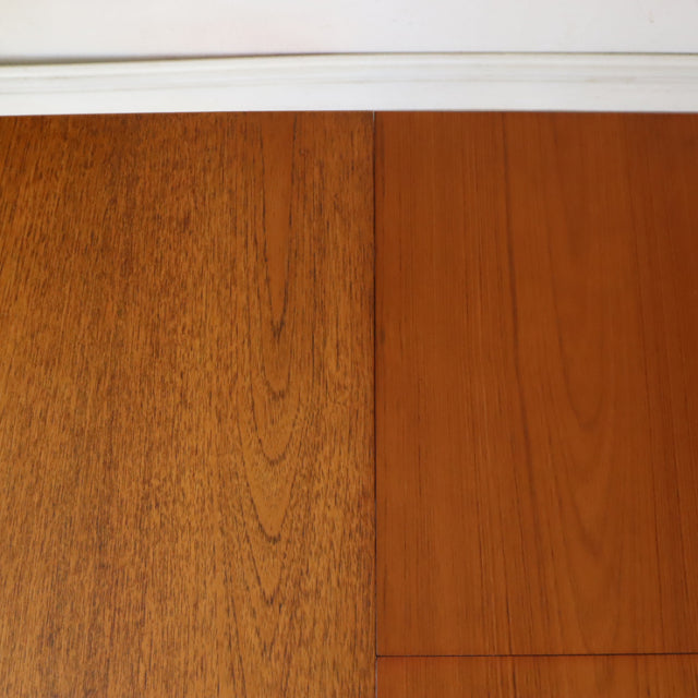 Close-up of vintage British mid-century teak dining table top showing rich wood grain and smooth finish.