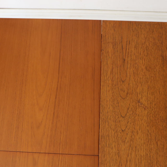 Close-up of vintage teak dining table with rich wood grain, smooth rectangular British mid-century design from White and.