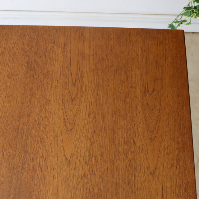 Mid-century British vintage dining table in teak with smooth grain and clean rectangular top.