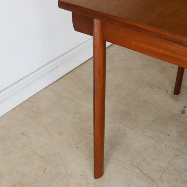 Mid-century British vintage teak dining table leg with smooth wood grain and tapered design.